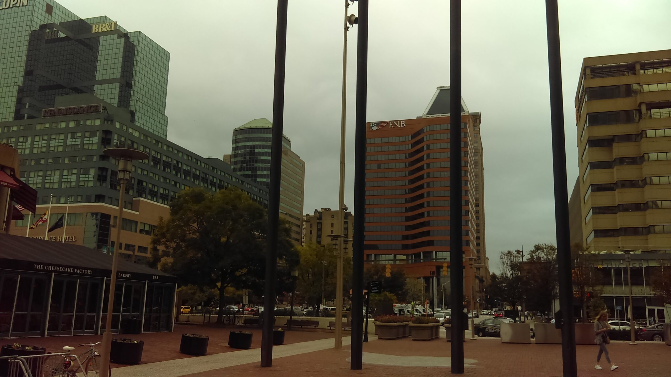 Urban plaza featuring modern skyscrapers, including BB&T and FNB buildings, with a cloudy sky. The scene captures city life and architecture.